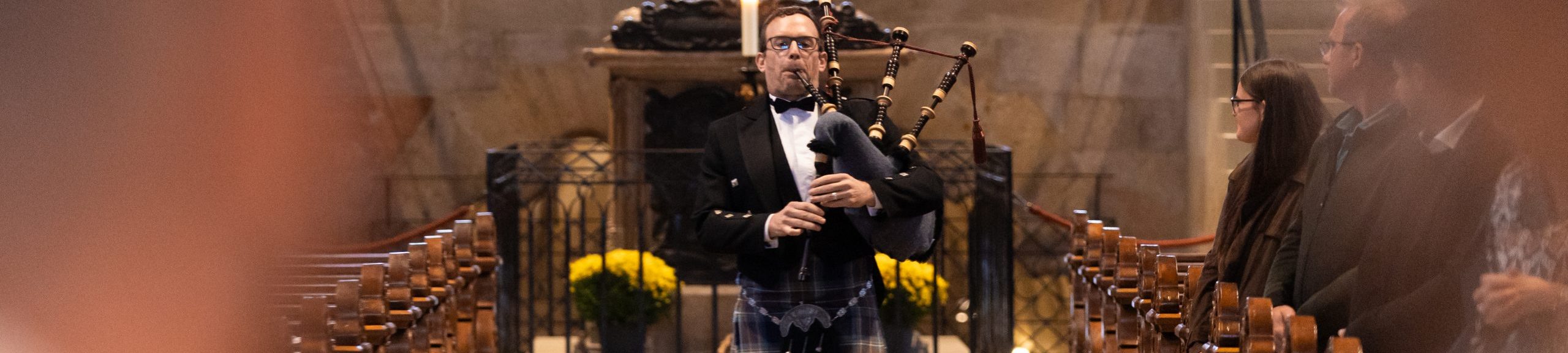 Zeigt, wie Dudelsack Spieler Sven Vollberg in eine Kirche einläuft